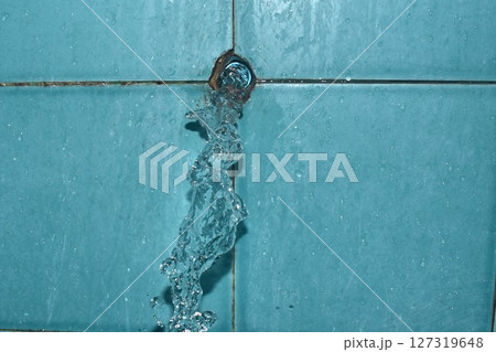 water splashing from broken plumbing blue polythene pipe line in bathroom 127319648