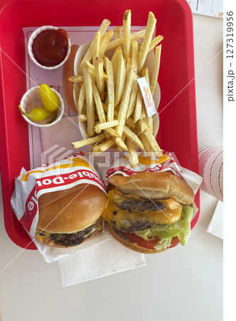 Tasty Burgers and Fries Served on a Red Tray With Condiments Tasty Burgers and Fries Served on a Red Tray With Condiments 127319956