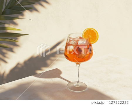 Aperol Spritz cocktail with orange slice and ice, natural neutral background with plant shadows and sunlight. 127322222