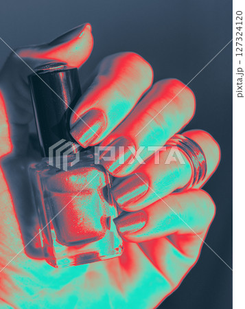 Infrared Thermal Image of Nail Polish on Well-Groomed Nails with nail polish bottle in hand. Close up Infrared Thermal Image o female hand with manicure and Nail lacquer bottle in fingers. Nail Polish 127324120