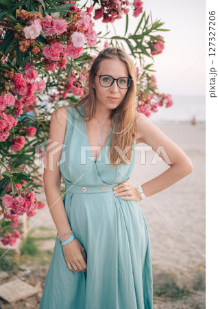 Elegant Woman Posing with Pink Flowers Outdoors 127327206