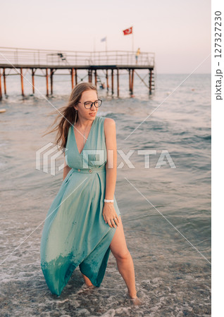 Woman in Flowing Dress on Seaside Pier Woman in Flowing Dress on Seaside Pier 127327230