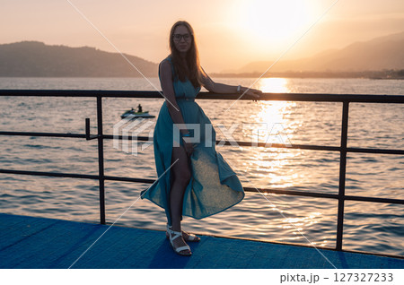 Woman in Flowing Dress on Seaside Pier Woman in Flowing Dress on Seaside Pier 127327233