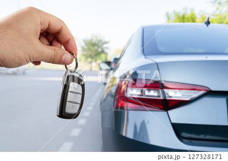 Automobile rent or leasing concept. Man's hand holding car key. Automobile rent or leasing concept. Man's hand holding car key. 127328171