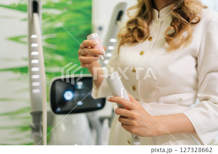 Closeup hands of unrecognizable cosmetic professional doctor assembling mesotherapy device preparing for cosmetic treatment in clinic of aesthetic medicine. Concept of innovative healthcare technology 127328662