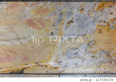 Worn Marble Floor Tiles with Earthy Tones and Dark Spots 127330139