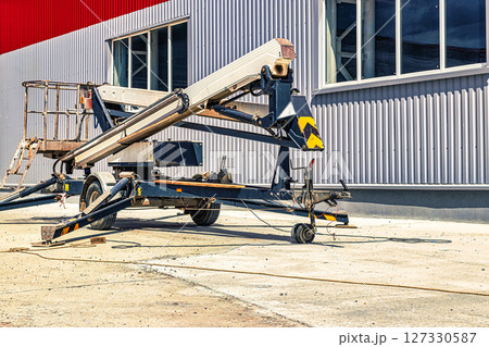 Construction telescopic tower or work platform for people to work at height. Powerful work platform for lifting construction workers up. 127330587