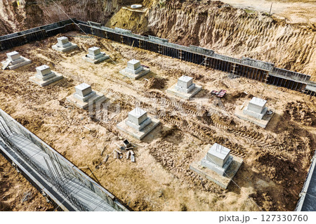 Monolithic reinforced concrete foundations or grillages for the construction of a large modern residential building. Rostverk at the construction site. Foundation for the building. View from above. Monolithic reinforced concrete foundations or grillages for the construction of a large modern residential building. Rostverk at the construction site. Foundation for the building. View from above. 127330760