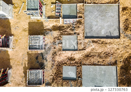 Monolithic reinforced concrete foundations or grillages for the construction of a large modern residential building. Rostverk at the construction site. Foundation for the building. View from above. Monolithic reinforced concrete foundations or grillages for the construction of a large modern residential building. Rostverk at the construction site. Foundation for the building. View from above. 127330763