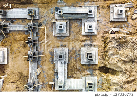 Monolithic reinforced concrete foundations or grillages for the construction of a large modern residential building. Rostverk at the construction site. Foundation for the building. View from above. Monolithic reinforced concrete foundations or grillages for the construction of a large modern residential building. Rostverk at the construction site. Foundation for the building. View from above. 127330772