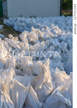 A sacks are filled with sand for use as a wall to prevent flooding in urban areas. 127331163