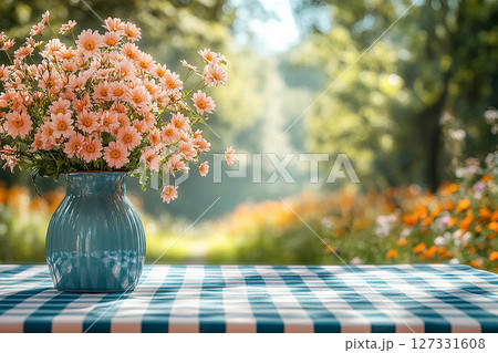 Picnic table with checkered tablecloth and a vase with flowers on a summer background. Retro-style. Mockup. Copy space. 127331608