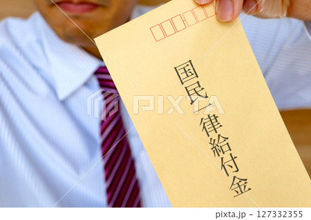 スーツの男性が国民一律給付と書かれた封筒を持っている スーツの男性が国民一律給付と書かれた封筒を持っている 127332355