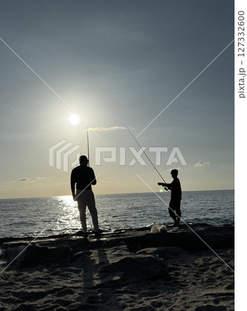 silhouette of a fisherman at sea sunset calm. High quality photo 127332600