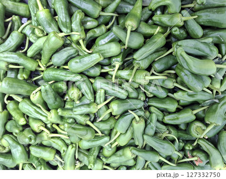 A large pile of padron green peppers ready for frying is showcased at a bustling market in Spain. The peppers boast a rich green color and are popular among local chefs. A large pile of padron green peppers ready for frying is showcased at a bustling market in Spain. The peppers boast a rich green color and are popular among local chefs. 127332750