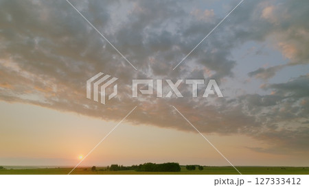 Time lapse. A Stunning Sunrise Gently Lights Up a Beautifully Serene Landscape Under a Gorgeous, Cloudy Sky 127333412