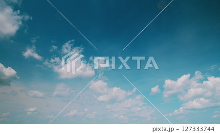 Time lapse. Behold the stunning beauty of a Blue Sky filled with fluffy White Clouds floating gracefully above Time lapse. Behold the stunning beauty of a Blue Sky filled with fluffy White Clouds floating gracefully above 127333744
