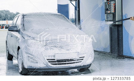 Man cleaning car. Spray hose foam soap. Car wash water shine exterior. Man cleaning car. Spray hose foam soap. Car wash water shine exterior. 127333785