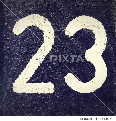 Number 23, White number on a dark background. Black and white old photo.  127334071