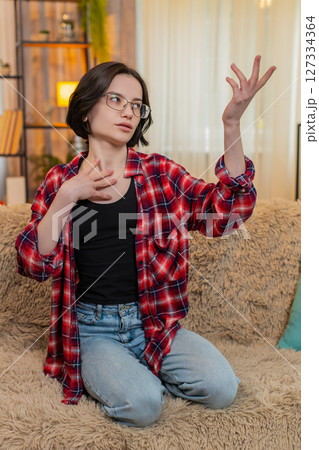 Young woman rehearsing monologue at home, gesturing with emotion and full theatrical engagement 127334364