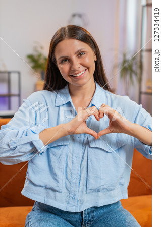 Caucasian young woman makes symbol of love showing heart sign to camera express romantic feelings 127334419
