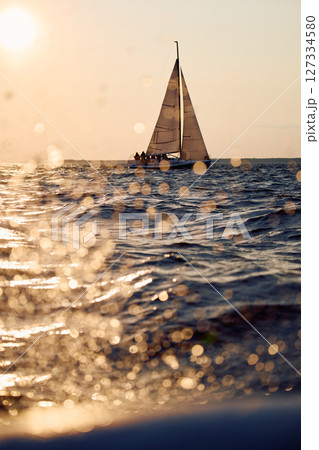 Sailing regatta in the Gulf of Finland at sunset, sailing yacht competing in a race, splashing water from under the boat, teamwork, board the boat 127334580