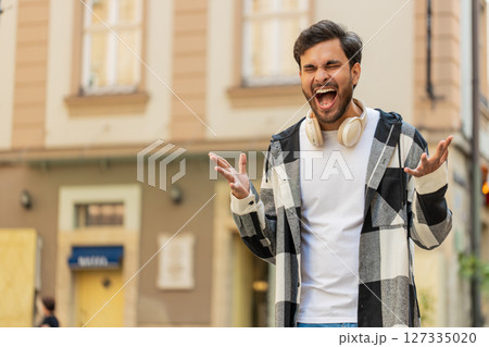 Indian young man screams yell shouts from stress tension problems feels horror in city street 127335020