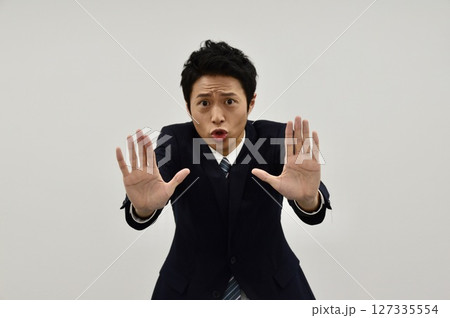 両手で「ストップ」のサインを出す若い男性 両手で「ストップ」のサインを出す若い男性 127335554