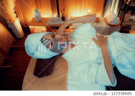 Woman indulges in rejuvenating with luxurious face cream spa massage. Quiescent 127336680