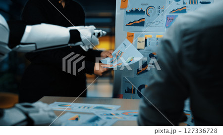 Futuristic Office Meeting with Robotic Arm Presenting Data Visualizations to Professional Team in Modern Workspace. Noogenesis 127336728