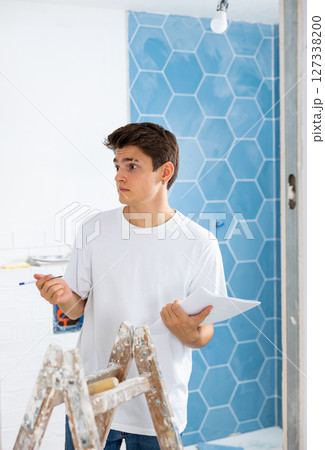 Confused young designer determining scope of work in apartment during refurbishment Confused young designer determining scope of work in apartment during refurbishment 127338200