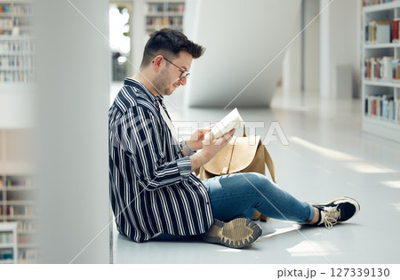 Man, student and reading in library with book for knowledge, education or learning at the university. Male learner in study with books for thesis, project or assignment for scholarship at the campus Man, student and reading in library with book for knowledge, education or learning at the university. Male learner in study with books for thesis, project or assignment for scholarship at the campus 127339130