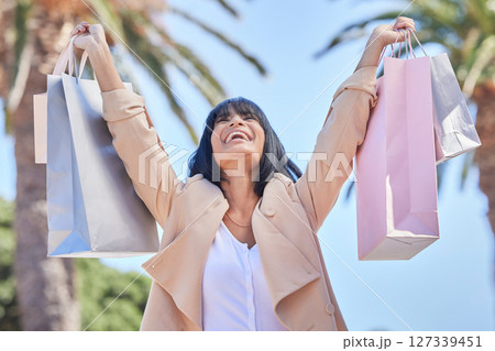 Success, shopping bag and celebration of woman in city after buying clothes on discount on Black Friday. Fashion, sales deal and happy female holding gifts and celebrating after purchase at mall. Success, shopping bag and celebration of woman in city after buying clothes on discount on Black Friday. Fashion, sales deal and happy female holding gifts and celebrating after purchase at mall. 127339451