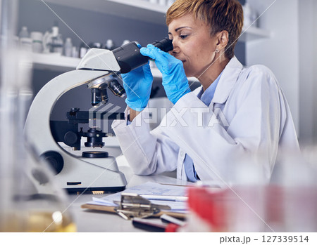 Science, laboratory and black woman with microscope, research for vaccine development. Healthcare, medical innovation and senior scientist woman in hospital lab looking at pharmaceutical test results 127339514