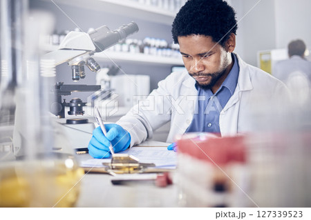 Black man writing report for science experiment, scientist in lab for research to test and study for scientific innovation. Biotechnology in laboratory, focus and knowledge, pen and checklist. 127339523
