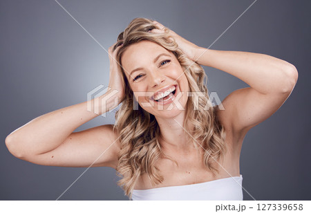 Portrait, beauty and hair with a model woman in studio on a gray background for keratin treatment or natural haircare. Face, skincare and wellness with a female posing to promote a haircare product Portrait, beauty and hair with a model woman in studio on a gray background for keratin treatment or natural haircare. Face, skincare and wellness with a female posing to promote a haircare product 127339658