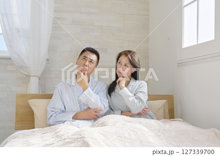 考えるパジャマを着た夫婦 127339700