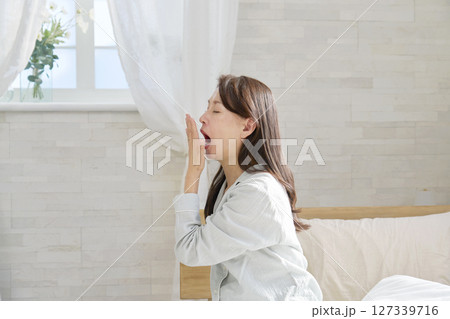 あくびをするパジャマを着た中年の女性　 127339716