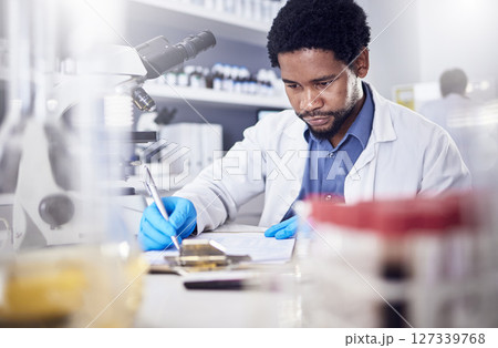 Black man writing report for science study, scientist in lab for research to test and experiment for scientific innovation. Biotechnology in laboratory, focus and knowledge, pen and checklist. Black man writing report for science study, scientist in lab for research to test and experiment for scientific innovation. Biotechnology in laboratory, focus and knowledge, pen and checklist. 127339768