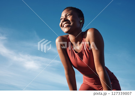 Fitness, black woman and happy athlete smile after running, exercise and marathon training workout. Blue sky, summer sports and run of a African runner breathing with happiness from sport outdoor Fitness, black woman and happy athlete smile after running, exercise and marathon training workout. Blue sky, summer sports and run of a African runner breathing with happiness from sport outdoor 127339807