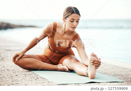 Exercise, woman and stretching on beach, workout and fitness for balance, wellness and health. Female, girl or training on seaside, zen or yoga practice for performance, healthy or pilates for energy 127339909