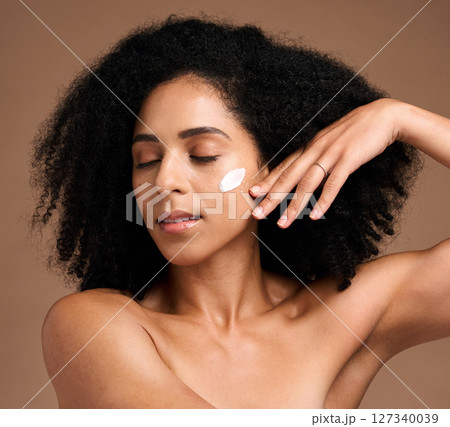Skincare, black woman and cream for face detox, organic facial and on brown studio background. African American female, girl and lotion for wellness, smooth and clear skin for beauty and cosmetics 127340039