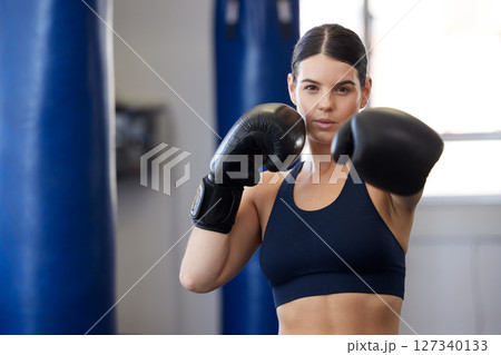 Fitness, kickboxing and portrait of woman athlete doing a cardio workout while training for a match. Sports, exercise and female boxer getting ready for a fight in sport, wellness and health gym. Fitness, kickboxing and portrait of woman athlete doing a cardio workout while training for a match. Sports, exercise and female boxer getting ready for a fight in sport, wellness and health gym. 127340133