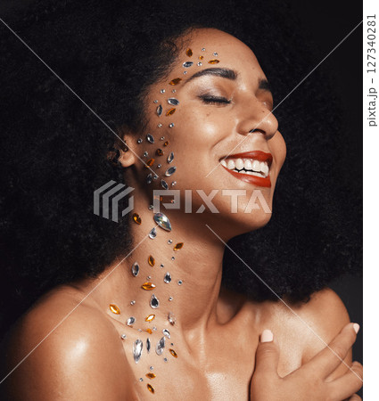 Woman face, body art jewels or diamond rhinestones on black background studio in fashion sparkle, festival accessory or creative party crystals. Happy smile, makeup beauty model or skin cosmetic gems 127340281