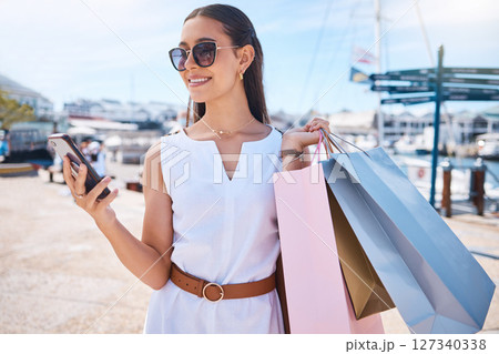 Woman, smartphone and shopping sale, discount and typing for social media, connection and outdoor. Female, customer and shopper with boutique clothes, expensive products and retail for luxury fashion Woman, smartphone and shopping sale, discount and typing for social media, connection and outdoor. Female, customer and shopper with boutique clothes, expensive products and retail for luxury fashion 127340338