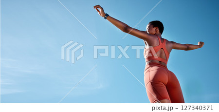 Woman, arms up or fitness success on blue sky background in workout, training or exercise goals for healthcare or cardiovascular wellness. Low angle runner, sports athlete or hands raised with mockup 127340371