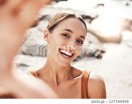 Selfie, beach and travel with a woman tourist taking a picture outdoor during summer vacation or holiday. Portrait, face and smile with an attractive young female happy on the coast by the sea Selfie, beach and travel with a woman tourist taking a picture outdoor during summer vacation or holiday. Portrait, face and smile with an attractive young female happy on the coast by the sea 127340948