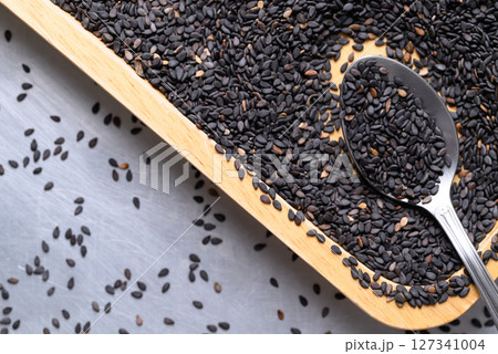Black sesame seed in spoon and wooden plate, Healthy eating, Top view Black sesame seed in spoon and wooden plate, Healthy eating, Top view 127341004