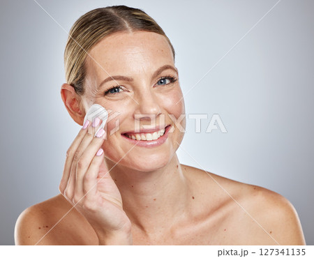 Skincare, cotton and portrait of woman in studio for cleaning, wellness and makeup removal on grey background. Face, skin and girl model with cotton pad for facial, wellness and cosmetic beauty Skincare, cotton and portrait of woman in studio for cleaning, wellness and makeup removal on grey background. Face, skin and girl model with cotton pad for facial, wellness and cosmetic beauty 127341135