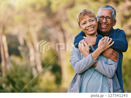 Nature, love and portrait of a senior couple hugging in a garden while on romantic outdoor date. Happy, smile and elderly people in retirement embracing in park while on a walk for fresh air together 127341243